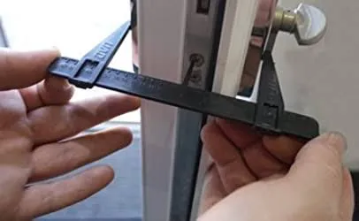 Perons hands measuring a door lock before picking.