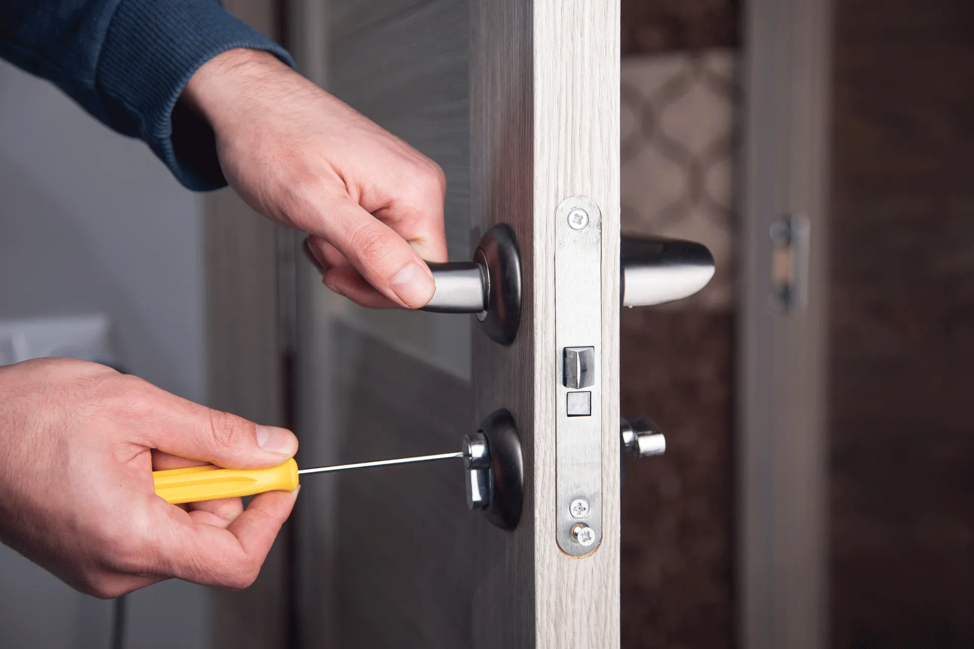 Person using a screw driver on a door.